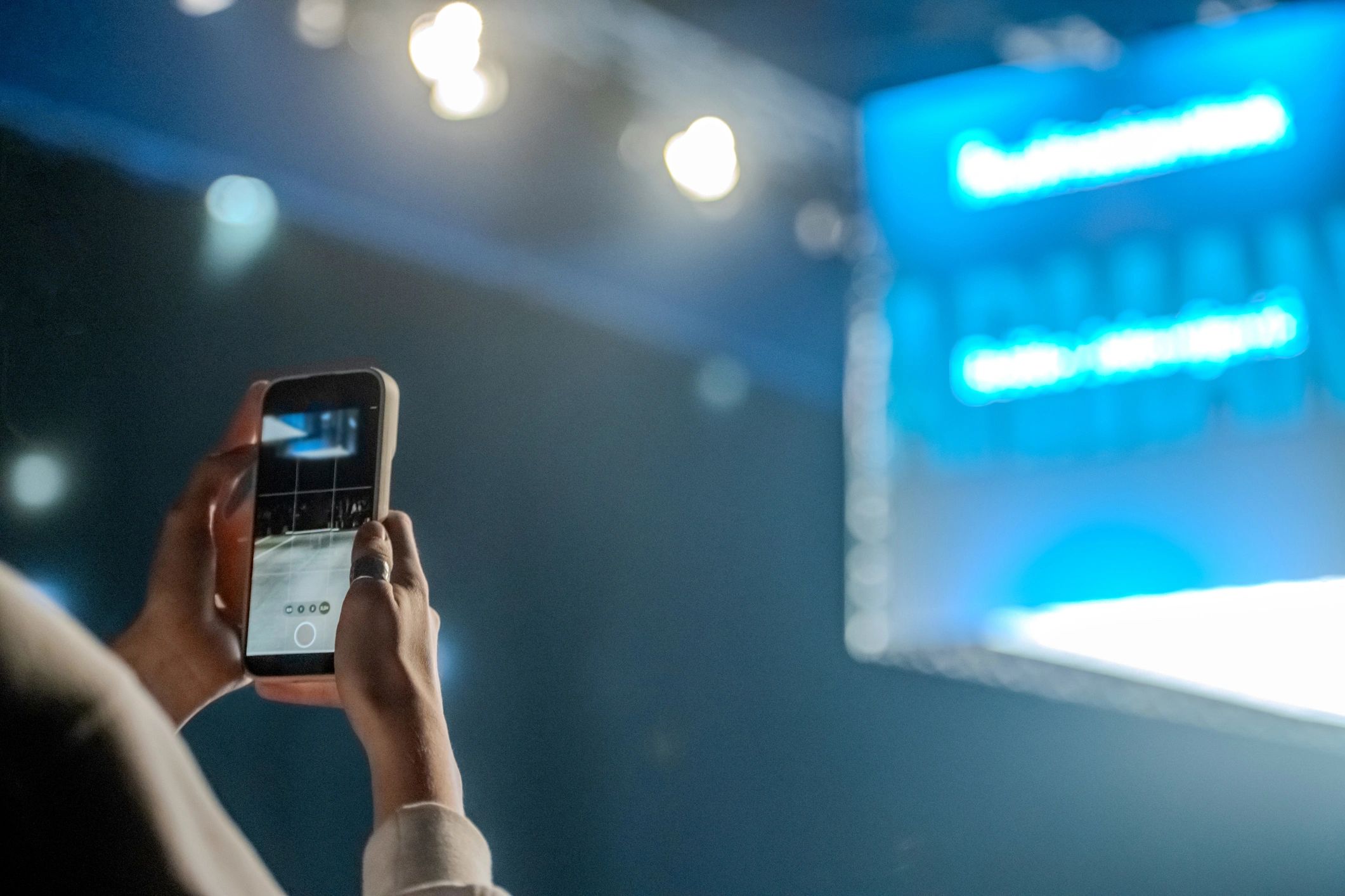 Audience filming a runway show with smartphones